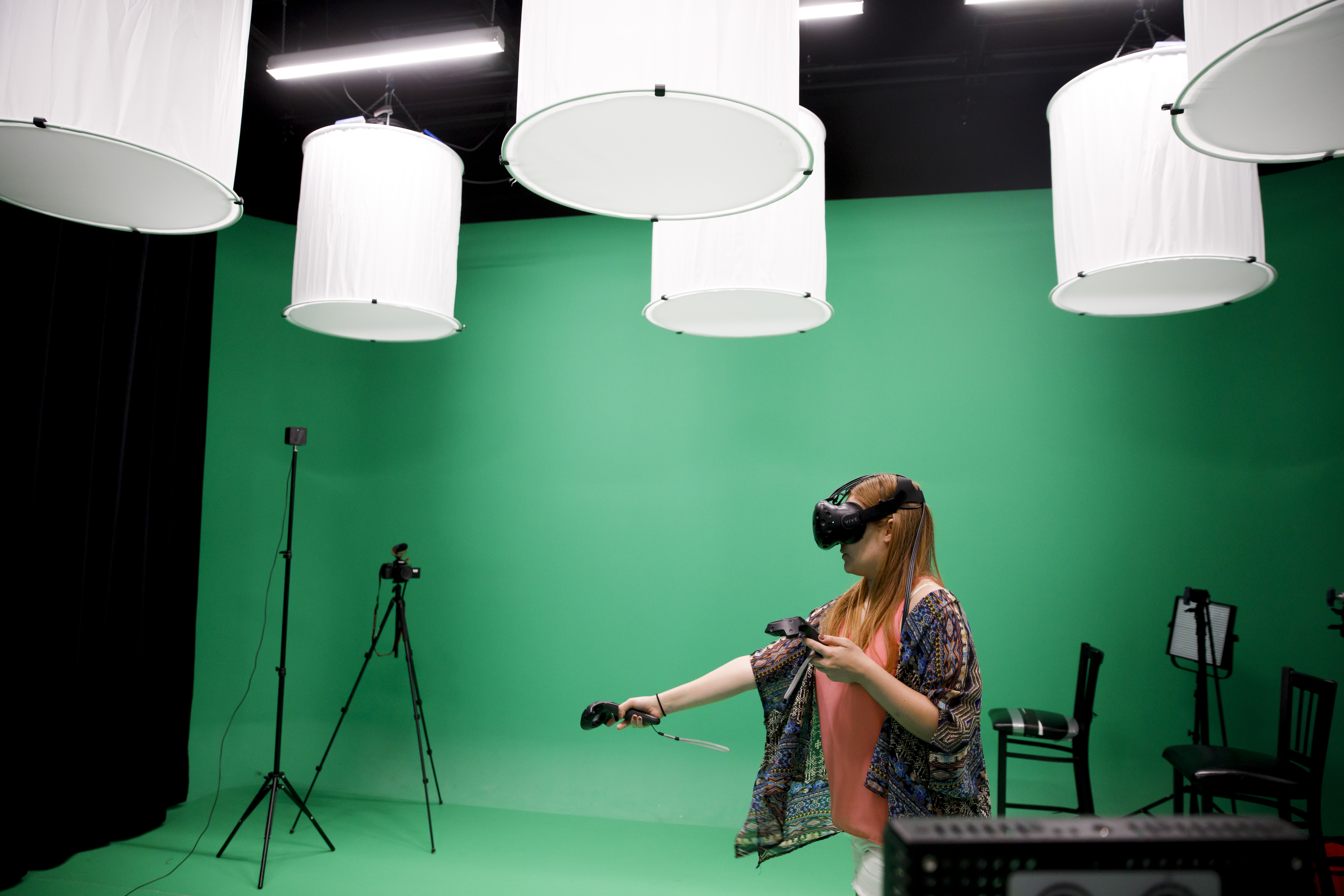 Image of a female student wearing a VR headset on a green background